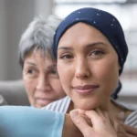 An Asian woman in her 60s embraces her mid-30s daughter who is battling cancer