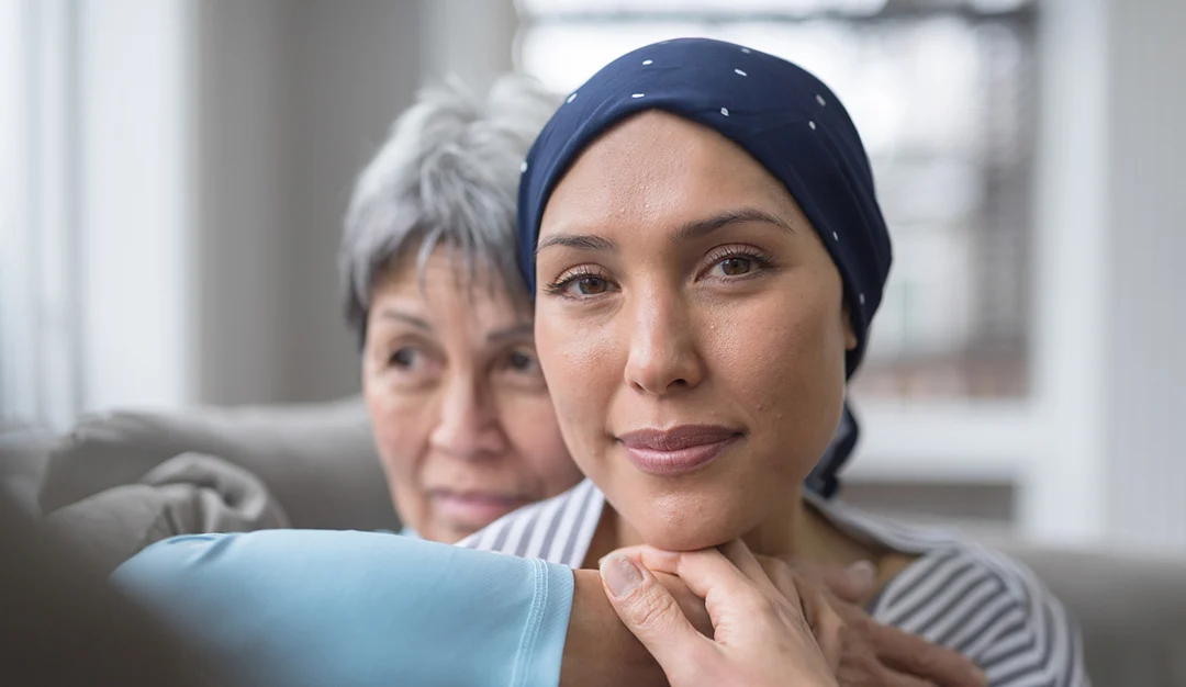 An Asian woman in her 60s embraces her mid-30s daughter who is battling cancer